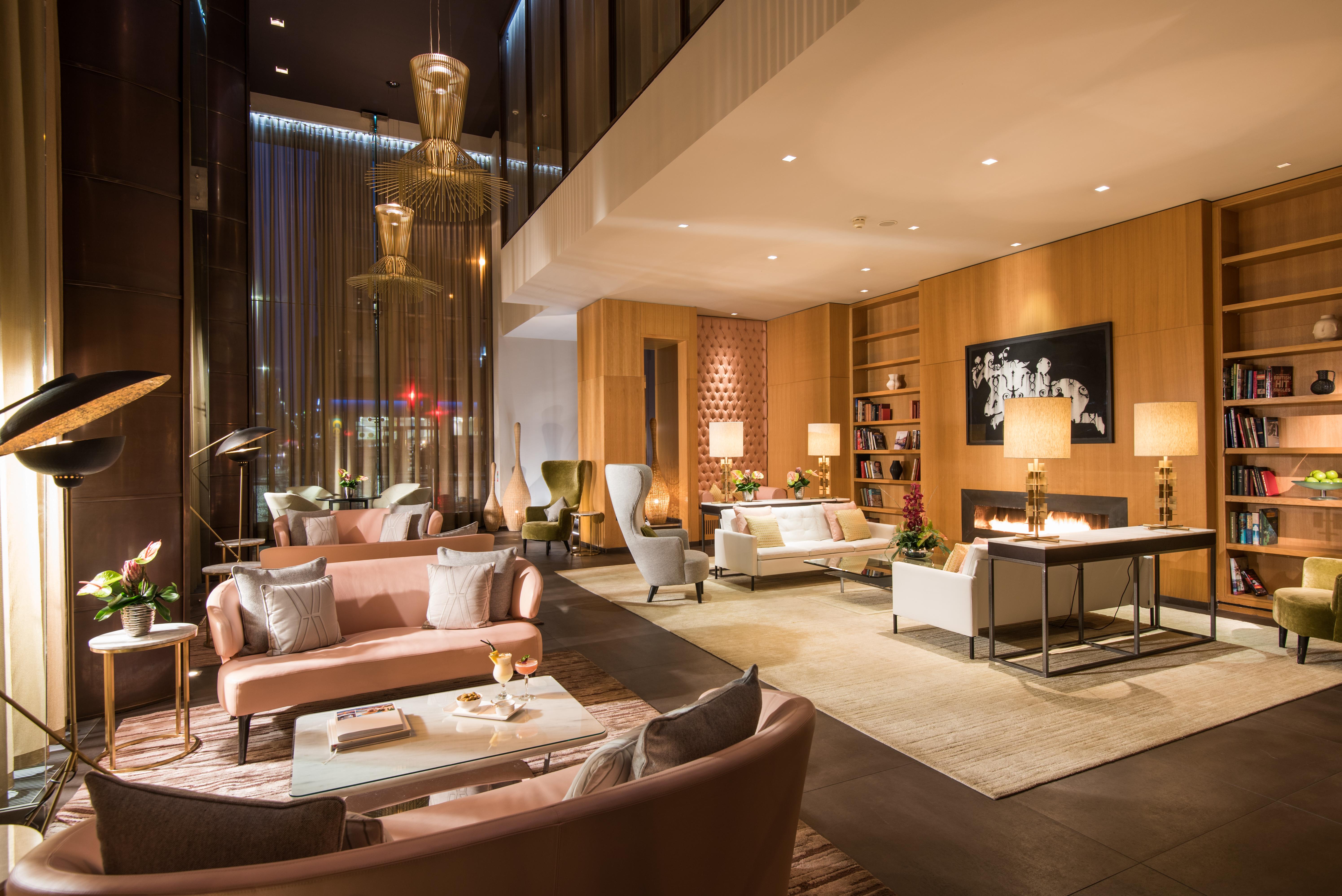 فندق ذا فيتزويليام بلفاست المظهر الخارجي الصورة The photo shows a modern and elegant lobby or lounge area. The space features a mix of contemporary and cozy furniture, including light-colored sofas and armchairs arranged around small tables. There are decorative elements like vases with flowers, a